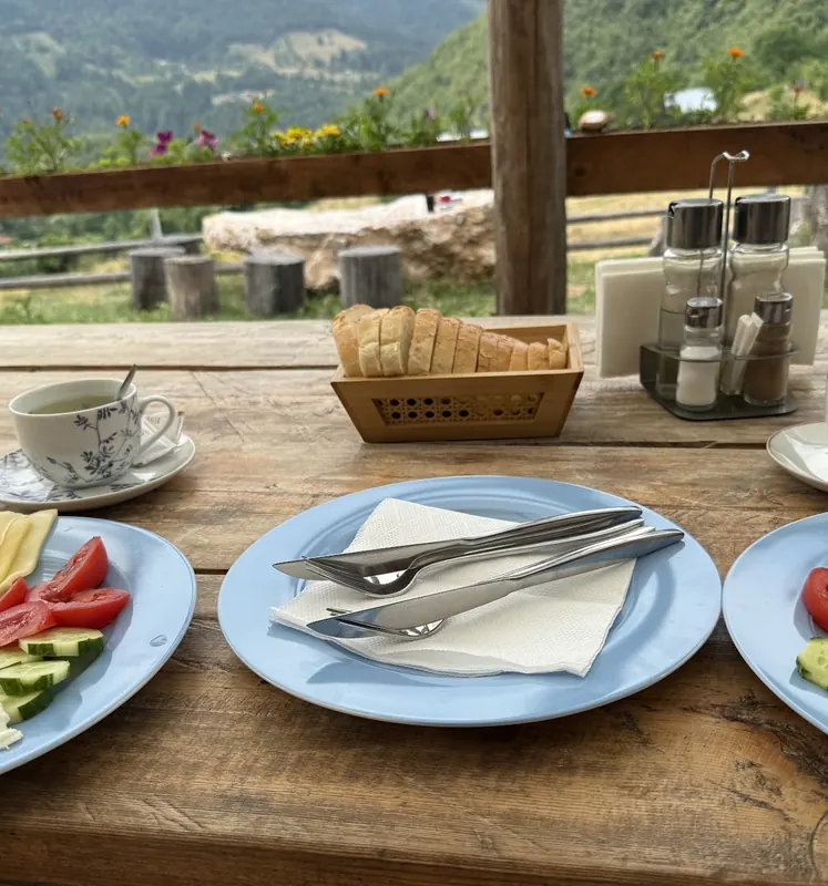 Breakfast plates with eggs, cheese and vegetables on the terrace above the valley