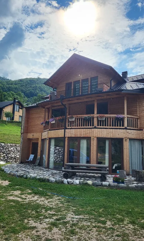 The guesthouse with its long wooden balconies under a bright sky