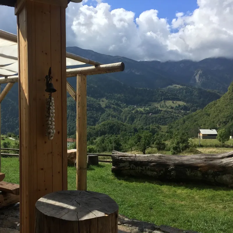 Covered terrace with wooden beams looking out over the Rugova valley